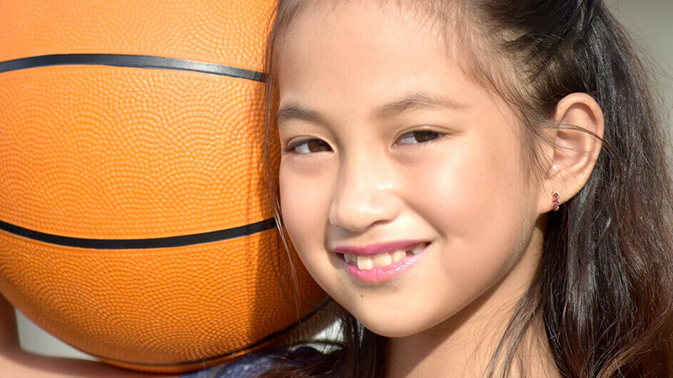 Lächelndes Mädchen mit Basketball