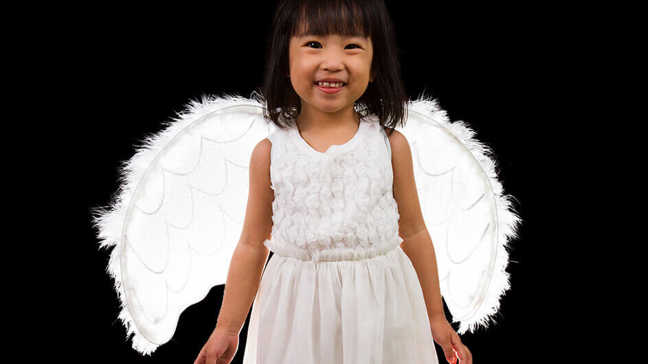 Ein lächelndes Kind als Engel verkleidet