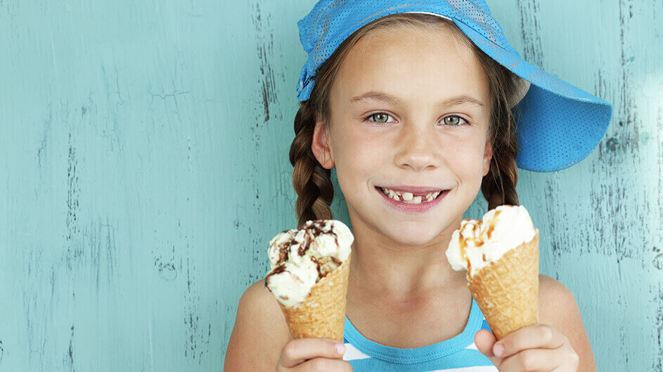 Ein lächelndes Mädchen mit jeweils einer Eiswaffel in der Hand