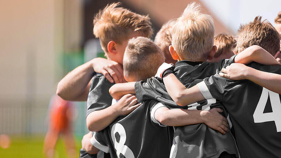 Kleine Jungen umarmen sich nach einem Vereinsspiel.